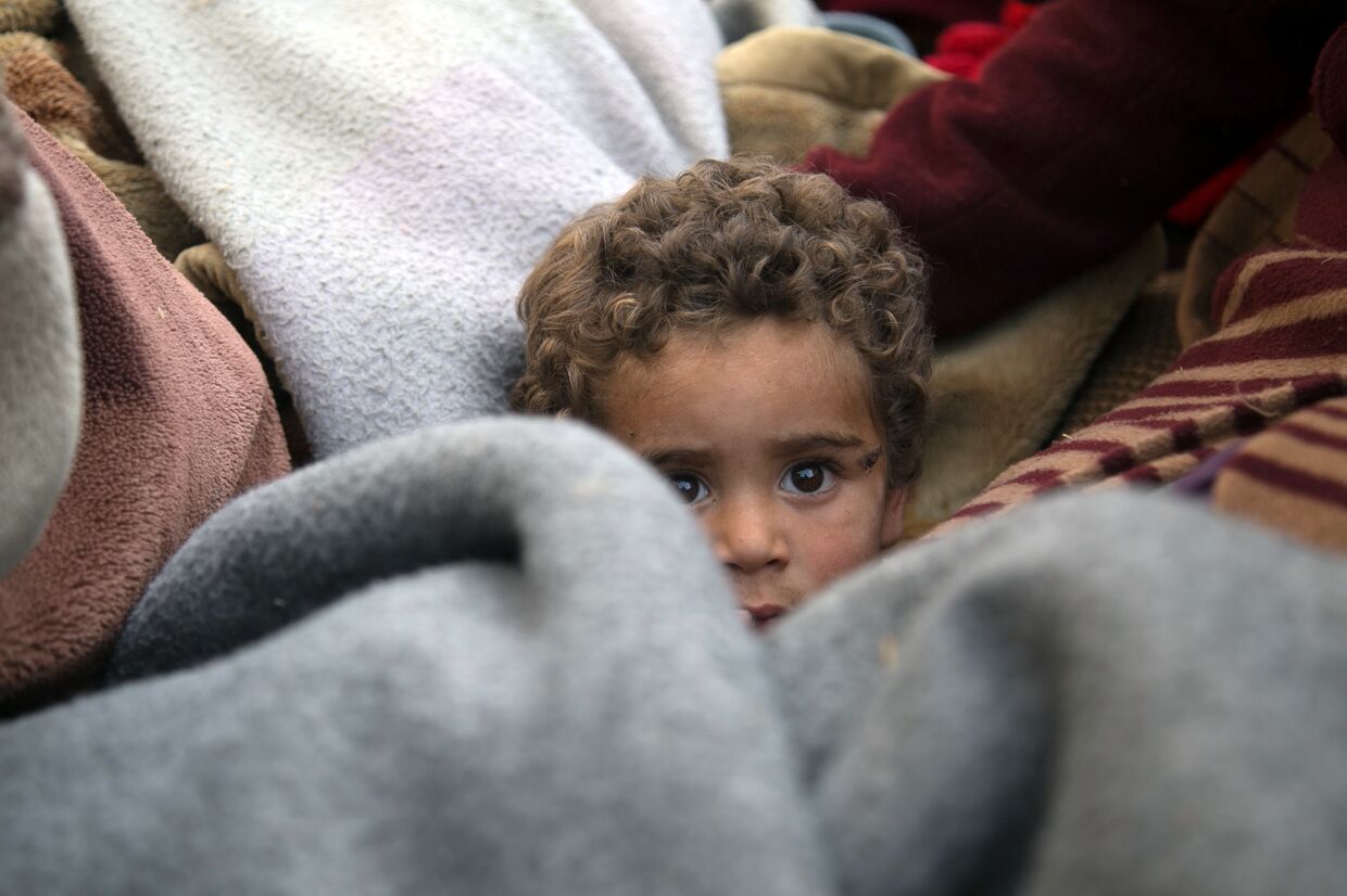 Ребенок в грузовике «Белых касок» покидает дом в городе Бейт-Сава, Сирия