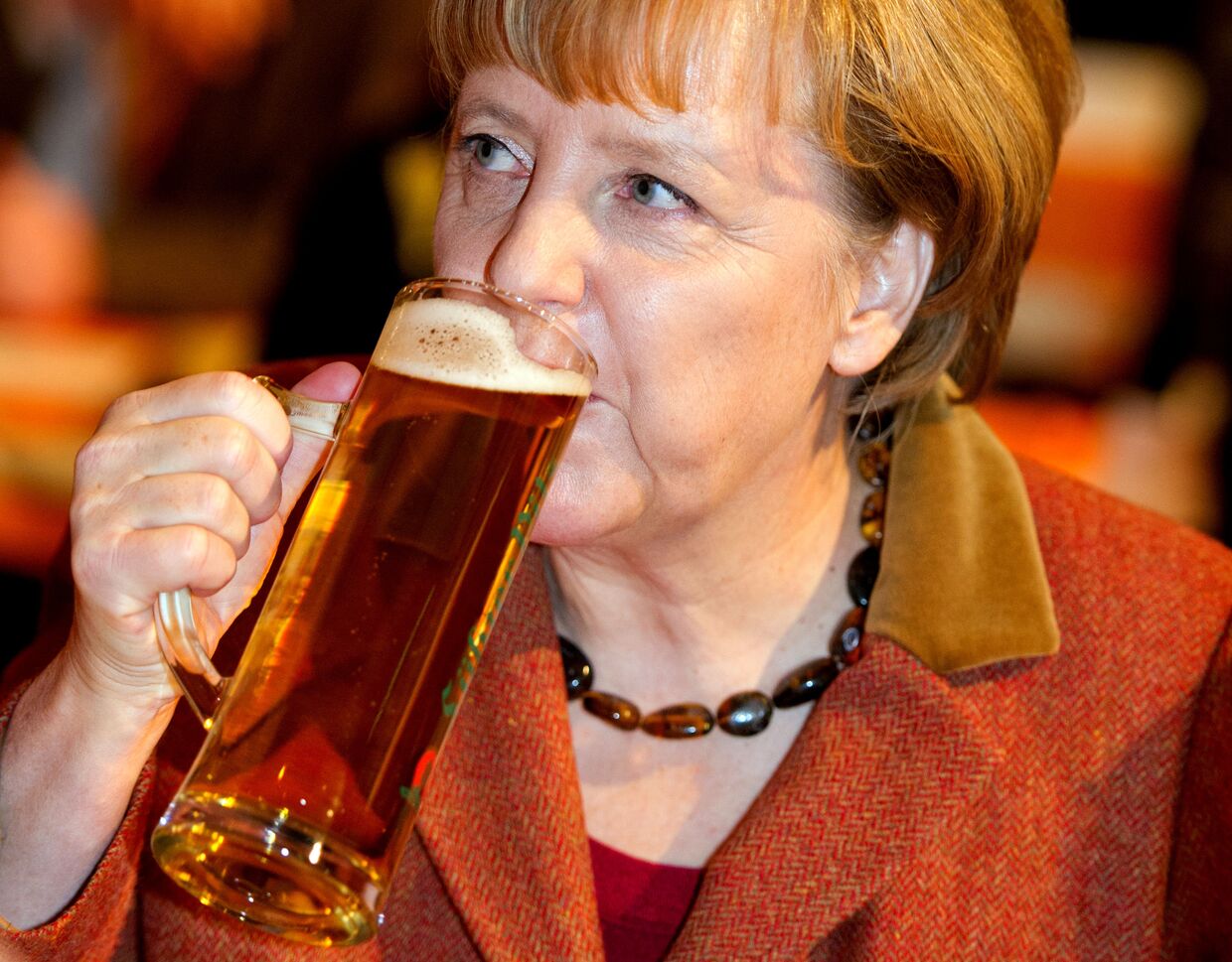 Канцлер Германии Ангела Меркель пьет пиво