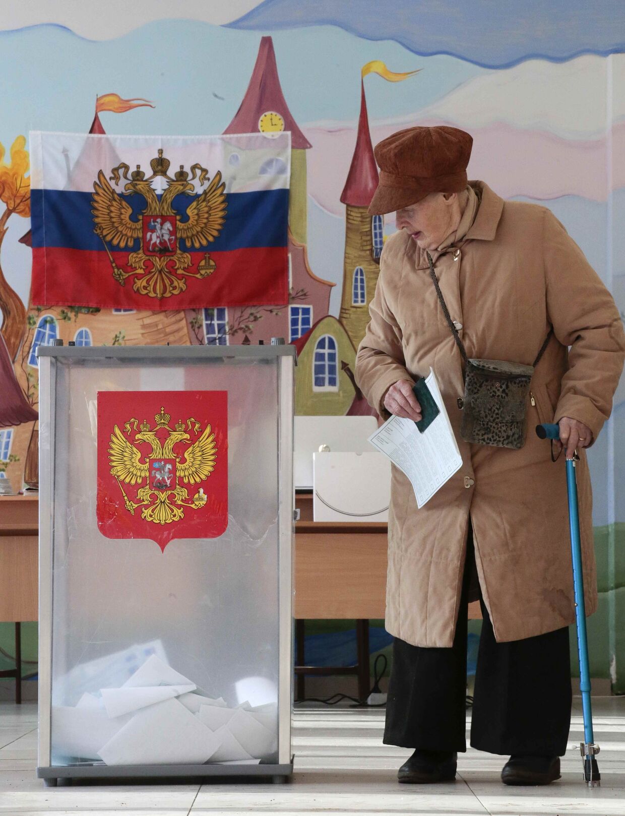 Пожилая женщина голосует на выборах президента РФ на избирательном участке в Санкт-Петербурге