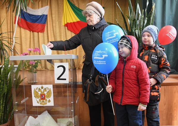 Женщина опускает бюллетень в урну на выборах президента Российской Федерации на избирательном участке в Чите. 18 марта 2018 Женщина опускает бюллетень в урну на выборах президента Российской Федерации на избирательном участке в Чите. 18 марта 2018