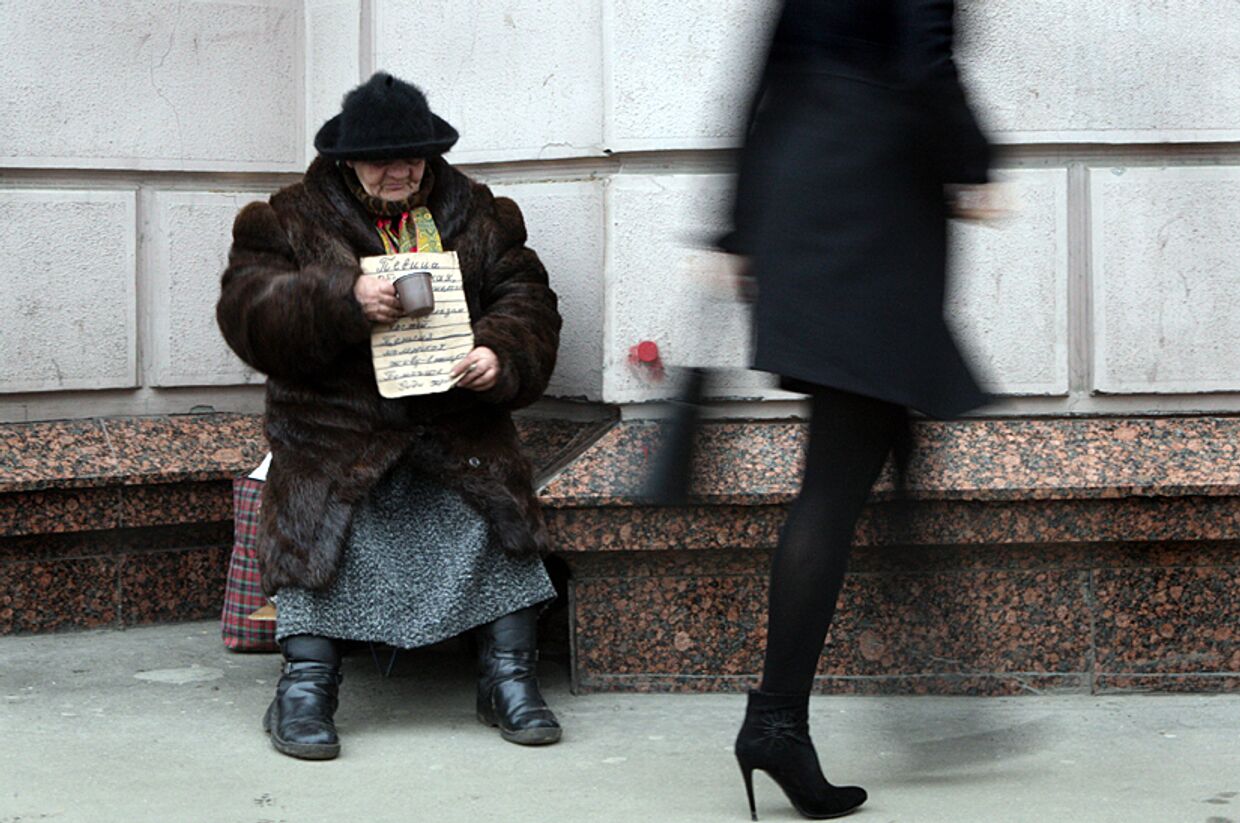 Женщина просит милостыню на одной из улиц Москвы