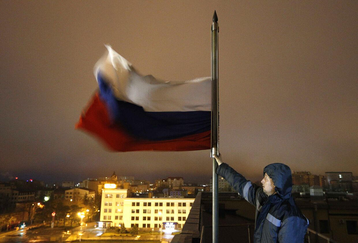 Приспущенный флаг в день траура по жертвам пожара в торговом центре в Кемерово