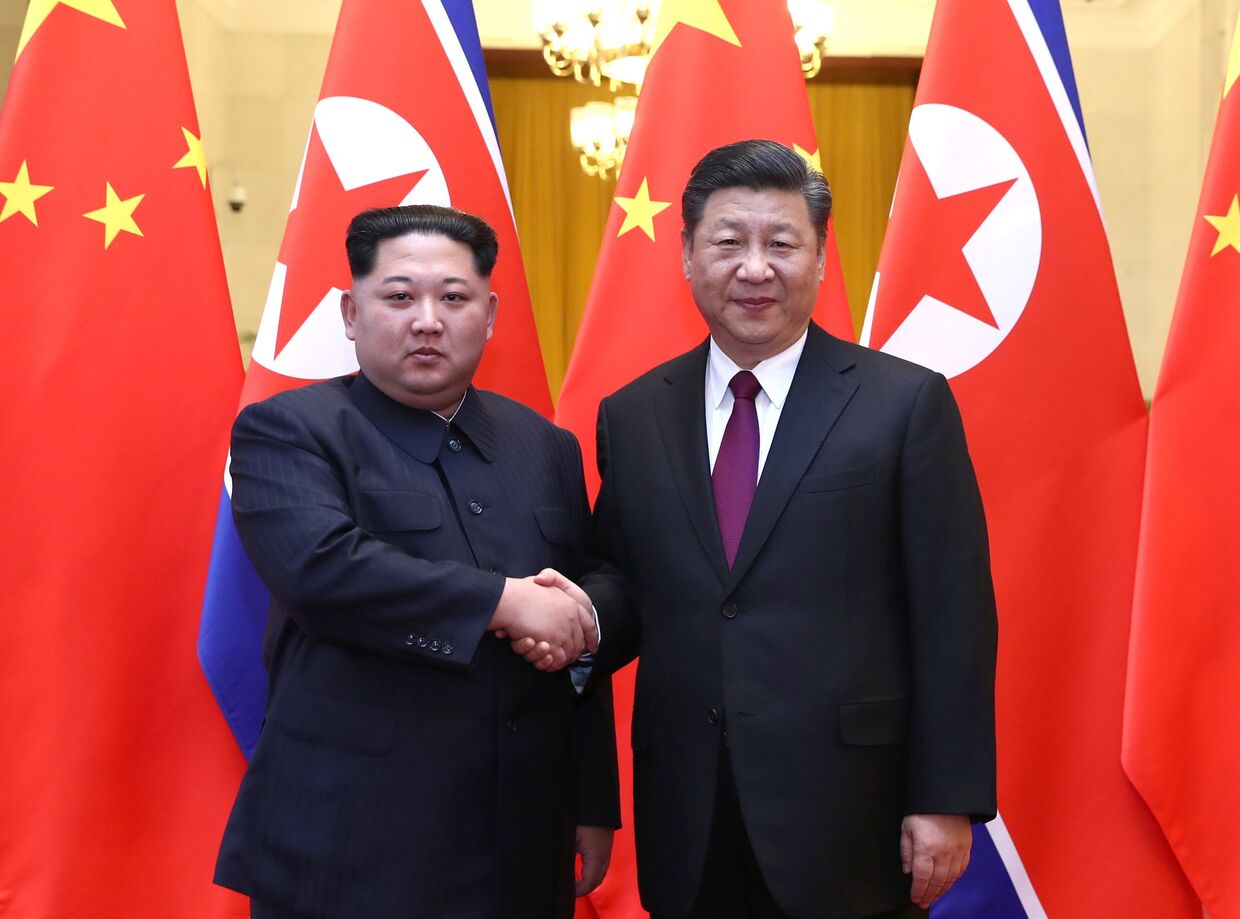 Северокорейский лидер Ким Чен Ын и председатель КНР Си Цзиньпин во время встречи в Пекине