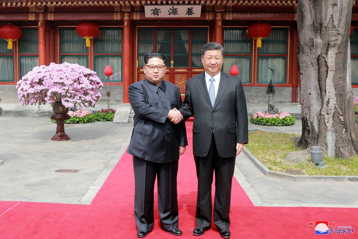 Северокорейский лидер Ким Чен Ын и председатель КНР Си Цзиньпин во время встречи в Пекине