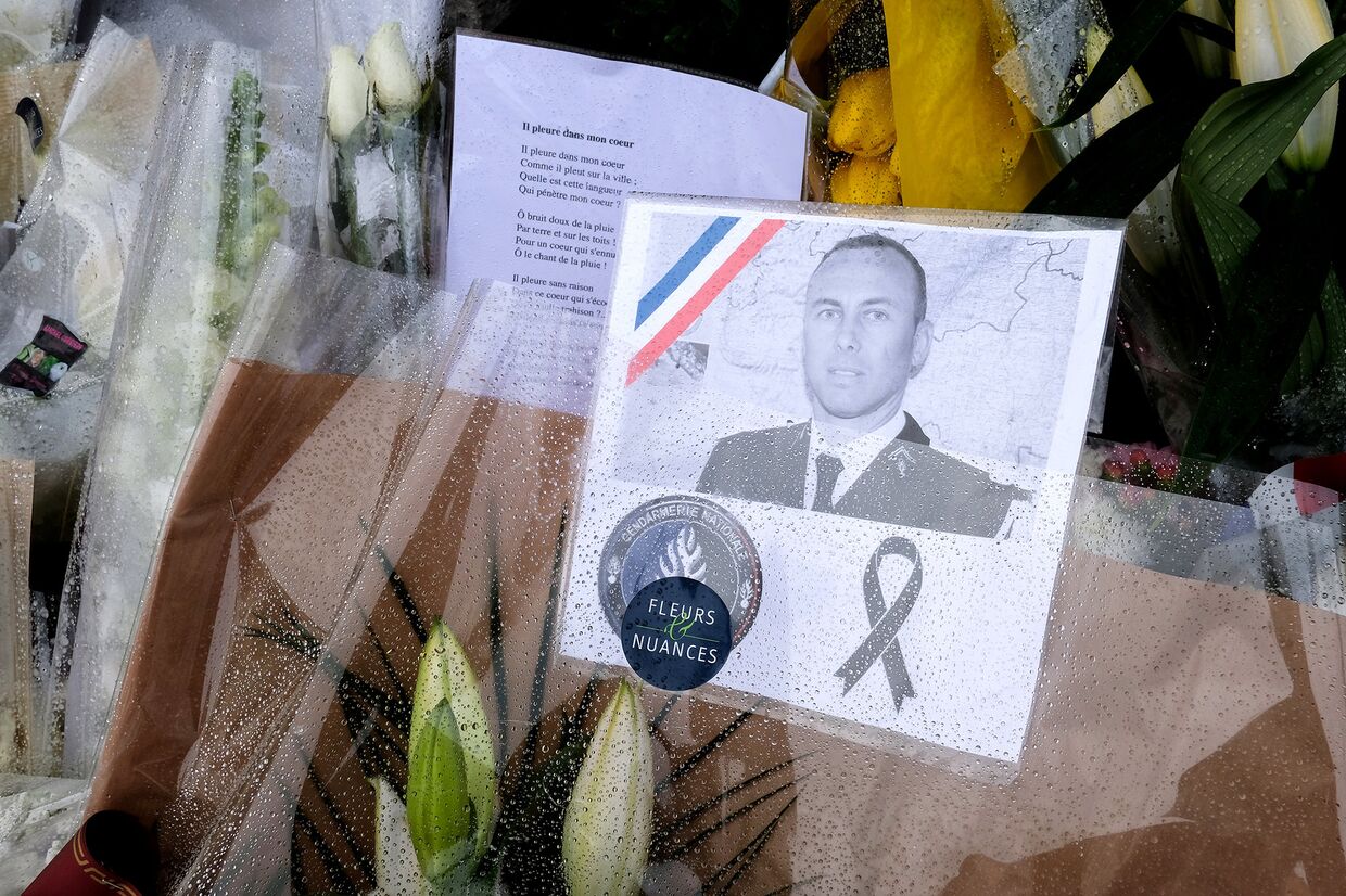 Цветы в память о подполковнике Арно Бельтраме, застреленном терорристом в супермаркете в Требе