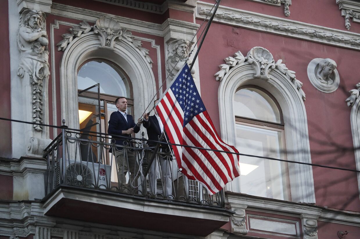 Сотрудники дипмиссии снимают государственный флаг США со здания американского генконсульства в Санкт-Петербурге