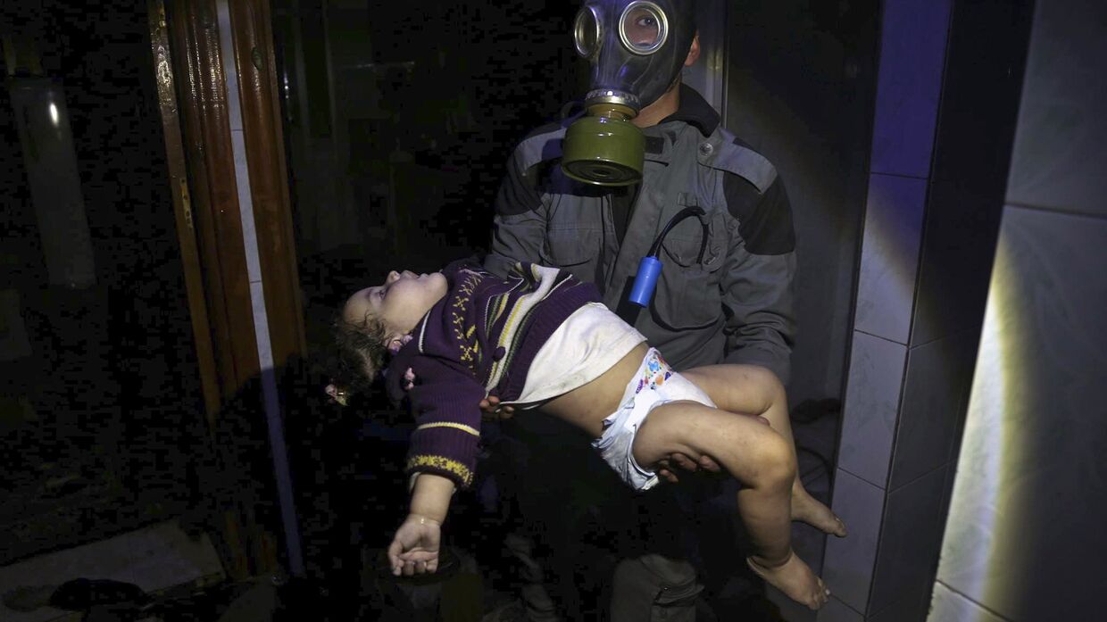 Спасатель несет ребенка после химической атаки в Думе, Сирия