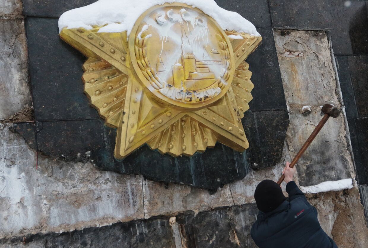Националист сбивает облицовку на Монументе Славы во Львове