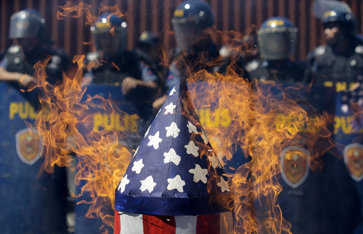 Горящий макет американской ракеты во время протестов у посольства США