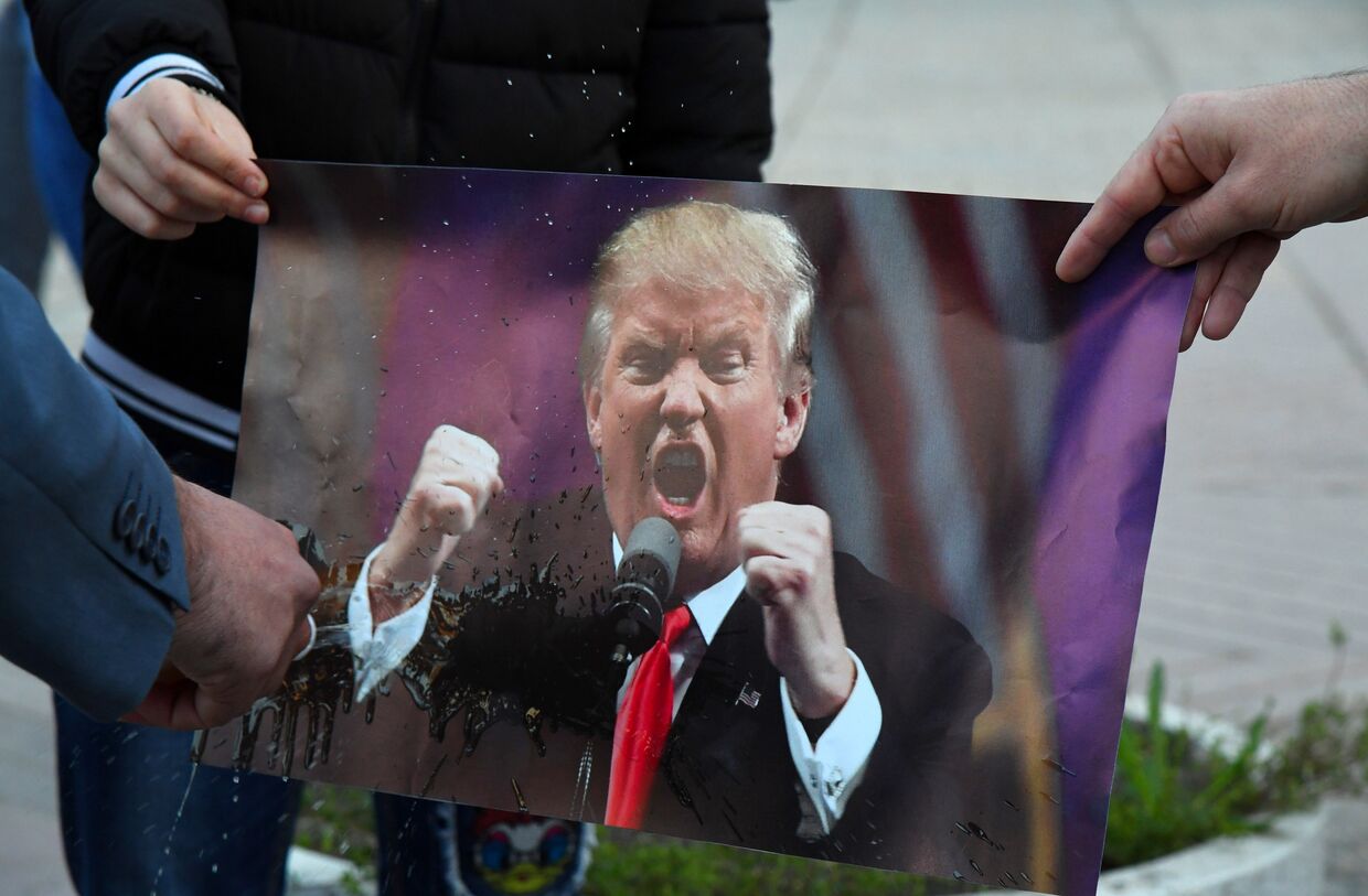 Участники акции протеста сжигают портрет президента США Дональда Трампа