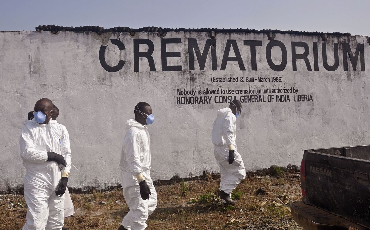 Медицинские работники в крематории на окраине Монровии, Либерия