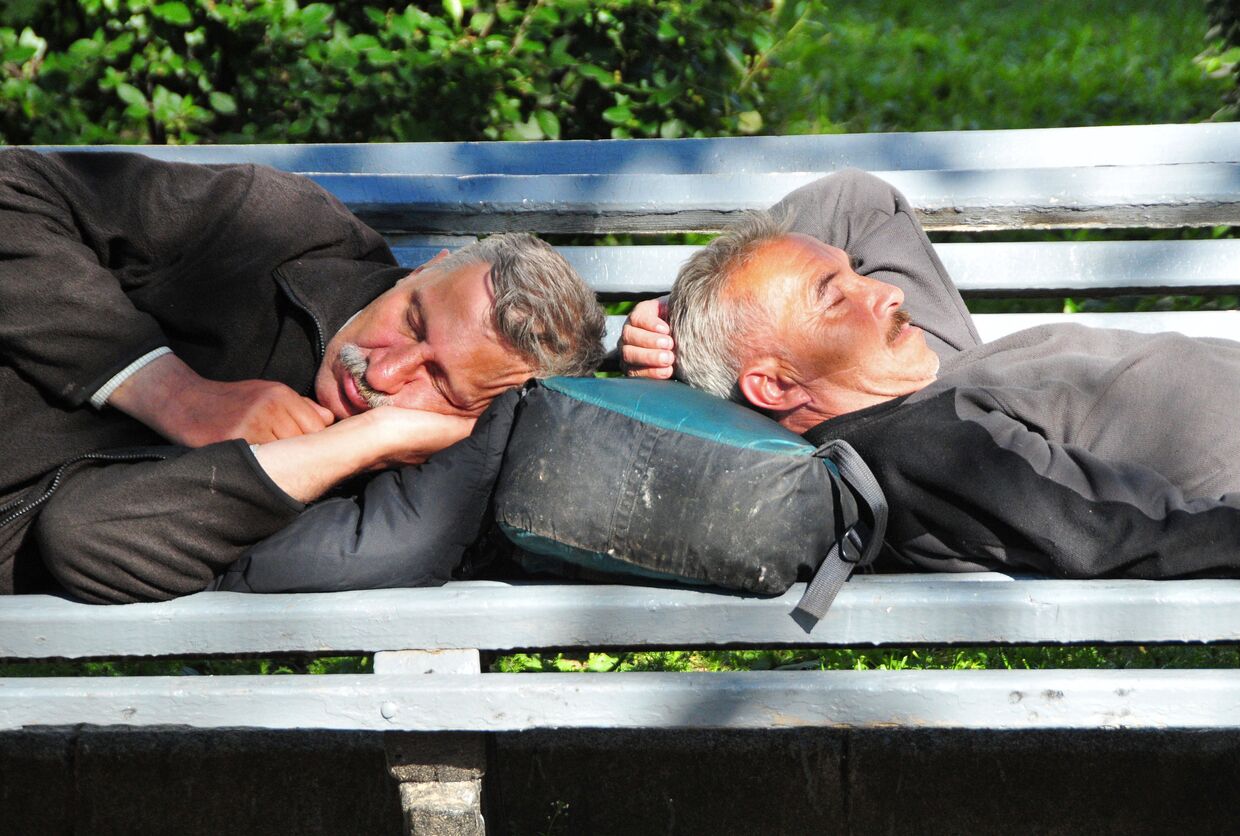 Мужчины спят на скамейке на Тверском бульваре в Москве