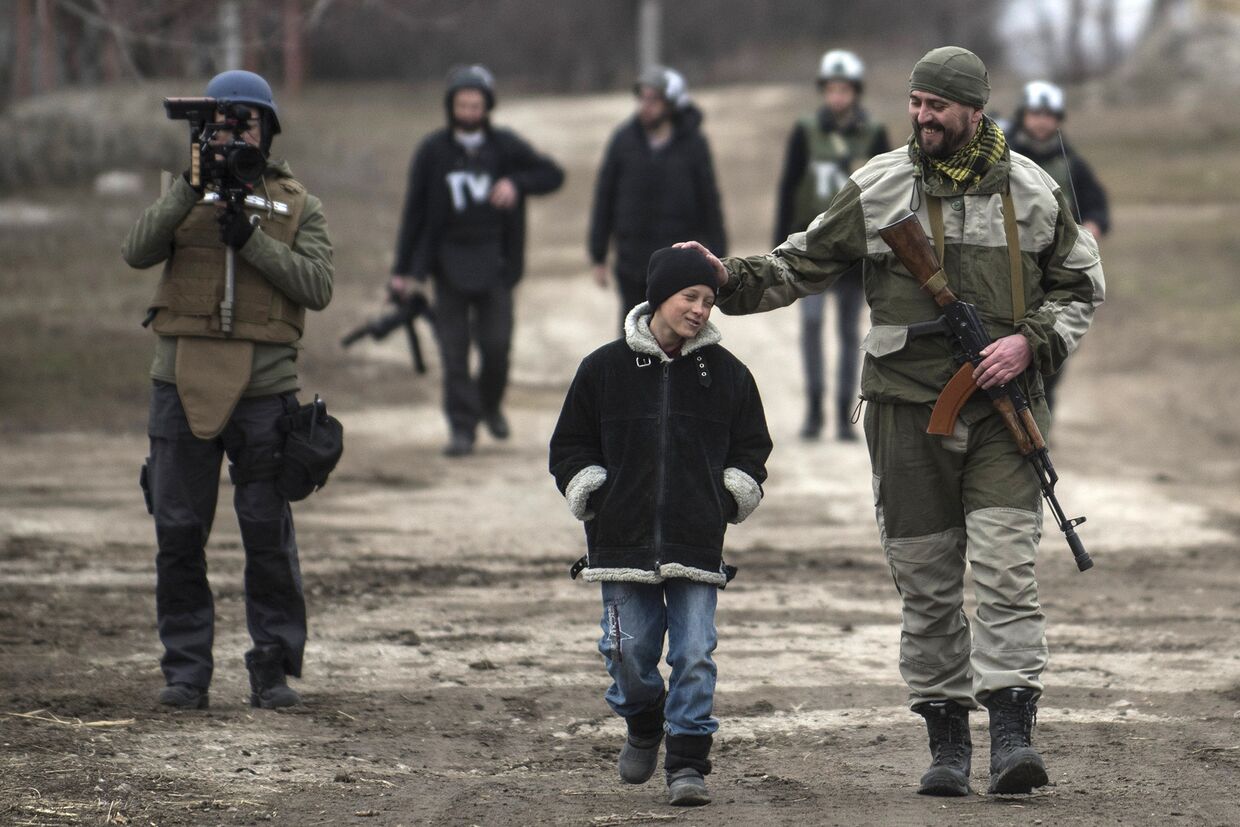 Украинский военный общается со школьником в селе Чермалык на востоке Украины