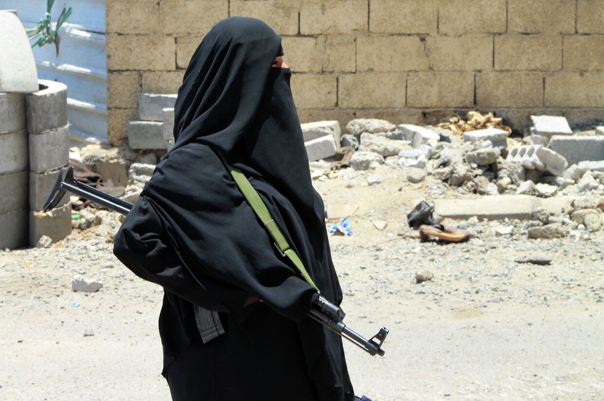 Вооруженная женщина на улице города Аден в Йемене
