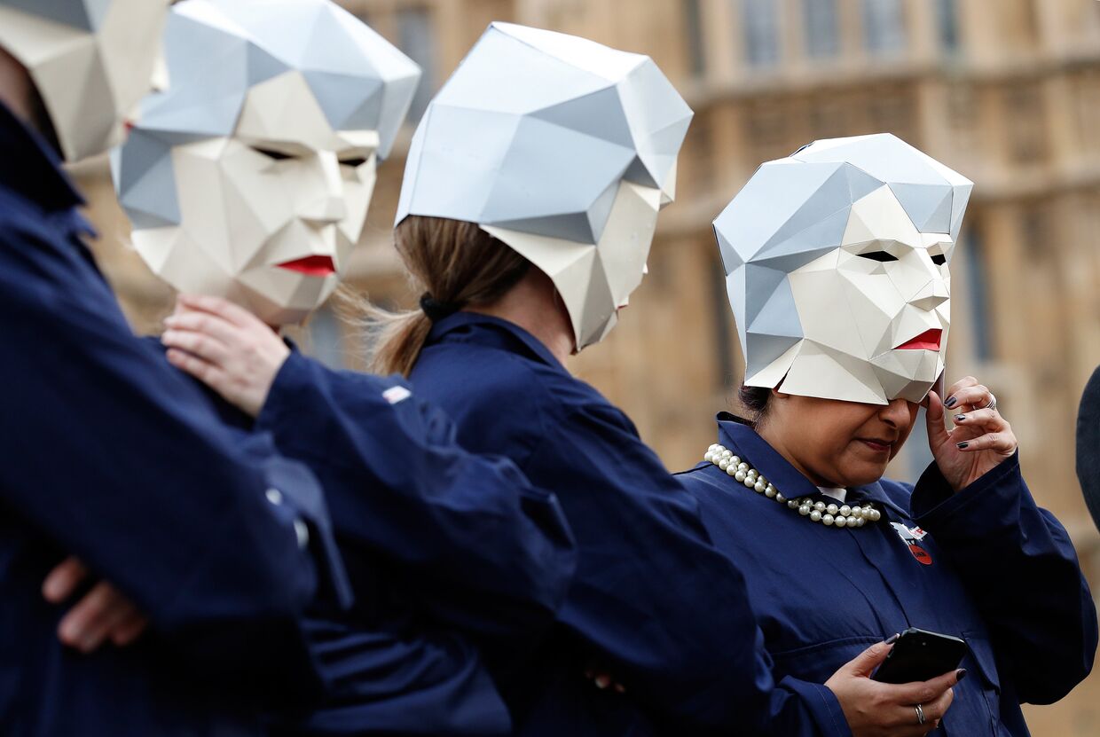 Участники акции протеста в Лондоне в масках, изображающих Терезу Мэй