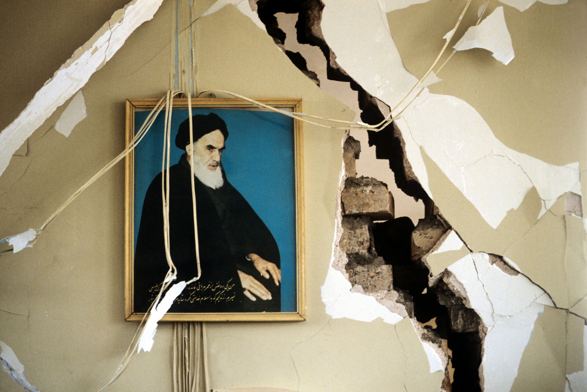 Портрет Высшего руководителя Ирана Рухолла Хомейни на стене разрушенного дома. 1990 - ИноСМИ, 1920, 10.02.2021