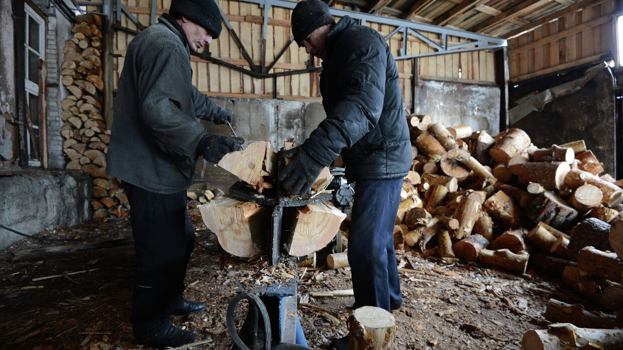 Рабочие перерабатывают на дрова отходы производства на лесопромышленном предприятии Абсолют-М