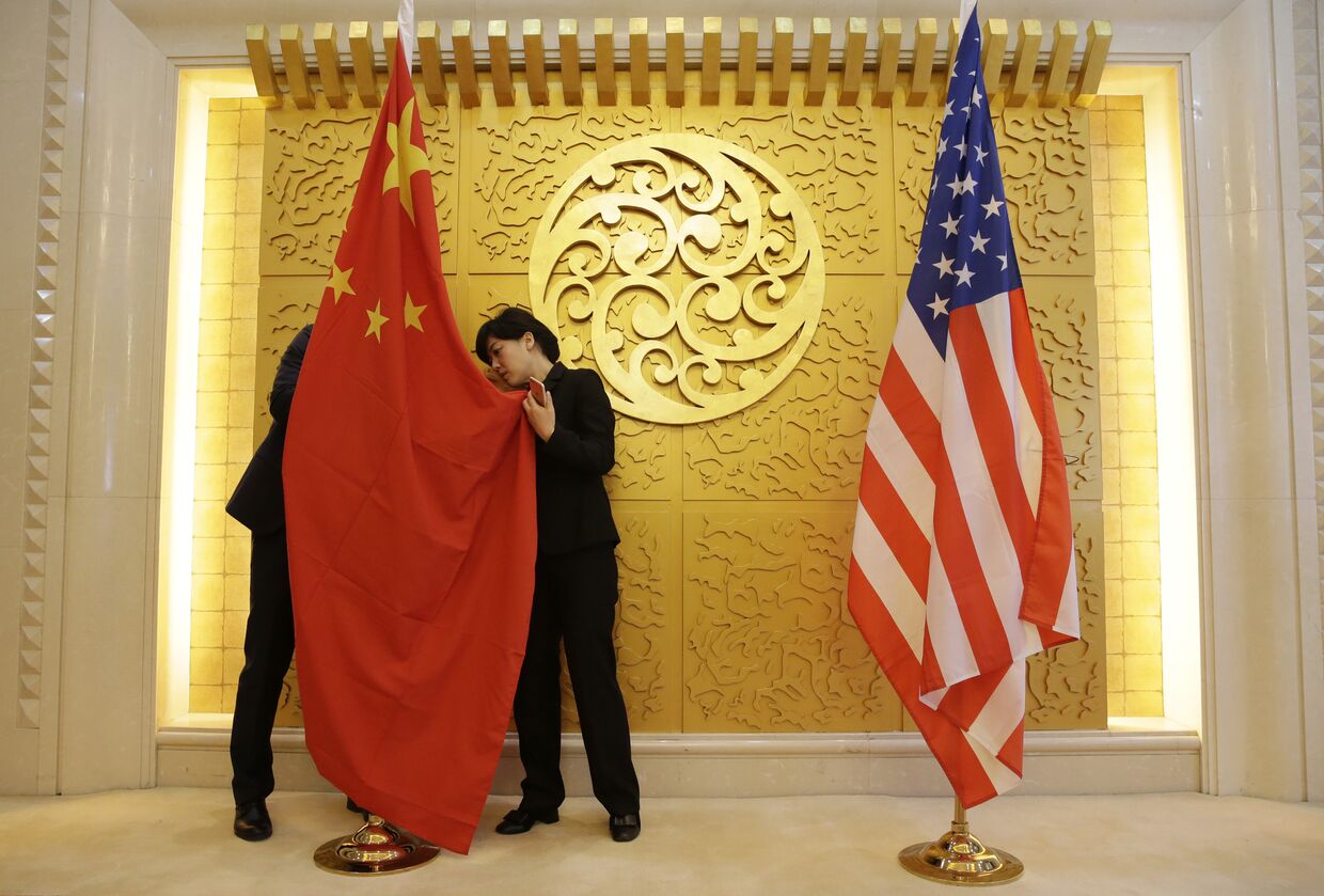 Служащие устанавливают флаг Китая перед встречей министра транспорта Китая Ли Сяопэна и министра транспорта США Элейн Лан Чао