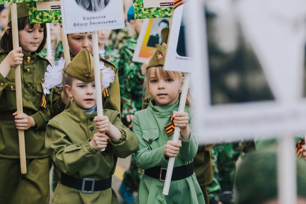 Участники акции Бессмертный полк, проходящего в рамках детского парада Победы Дорогами памяти в Иванове. 8 мая 2018 года