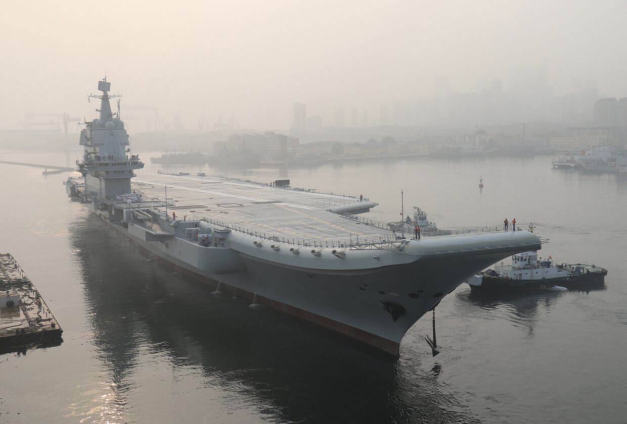Китайский авианосец покидает порт в городе Далянь для морских испытаний