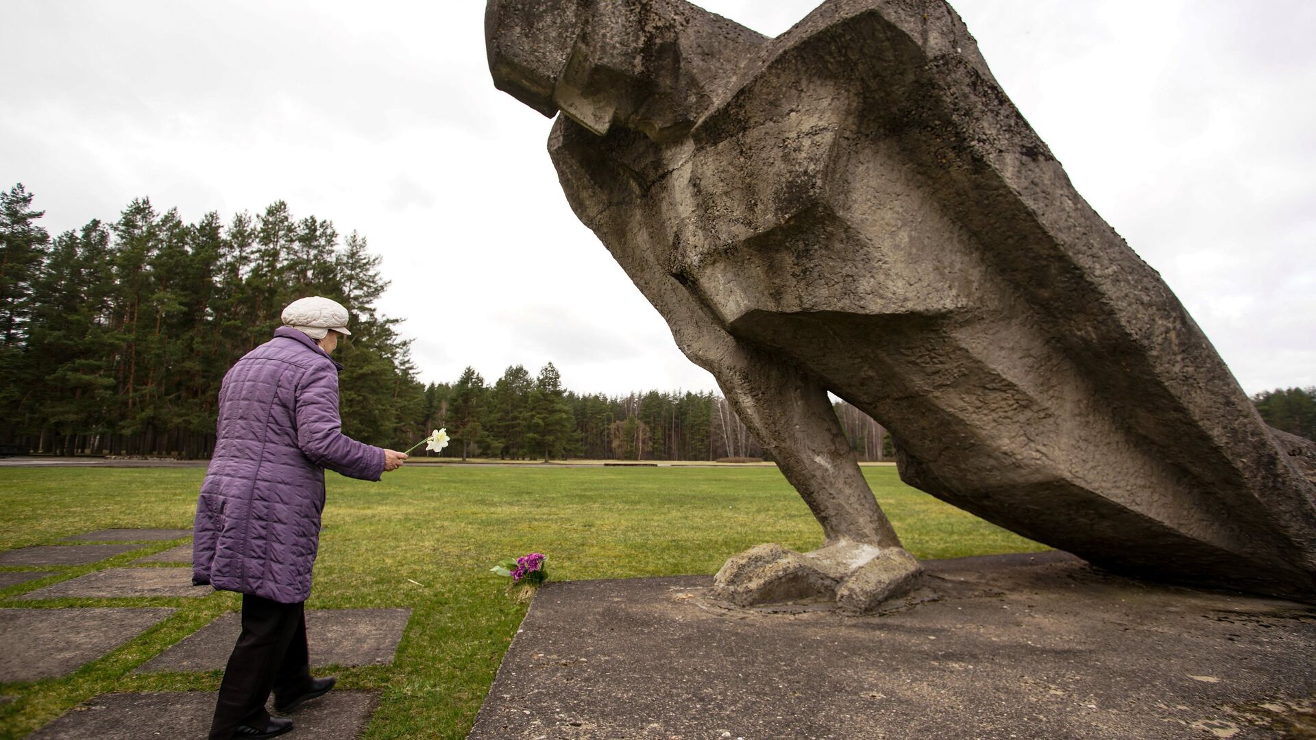 Женщина возлагает цветы к мемориалу памяти жертв фашизма на месте концлагеря Саласпилс в Латвии - ИноСМИ, 1920, 19.12.2023