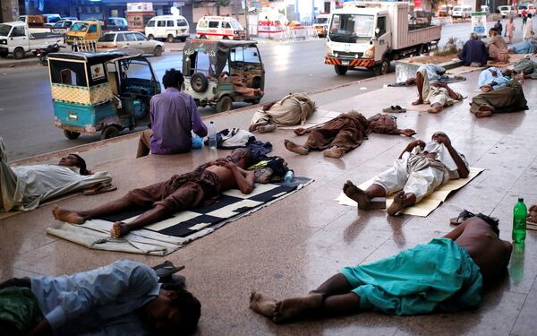Местные жители спят на тратуарах спасайсь от жары и отключений электроэнергии в Карачи, Пакистан