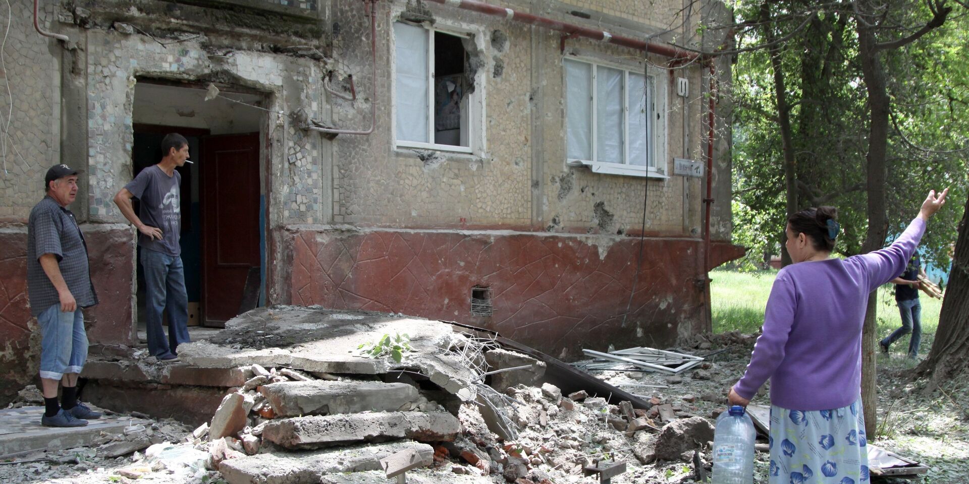 Жители во дворе жилого дома, пострадавшего в результате обстрела, в поселке Горловка Донецкой области - ИноСМИ, 1920, 11.08.2023