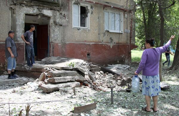 Жители во дворе жилого дома, пострадавшего в результате обстрела, в поселке Горловка Донецкой области Жители во дворе жилого дома, пострадавшего в результате обстрела, в поселке Горловка Донецкой области