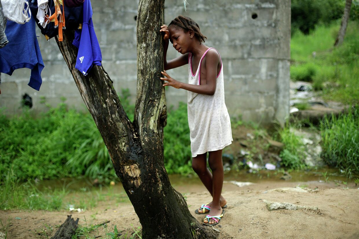 Девятилетняя жительница Монровии оплакивает свою мать, погибшую от лихорадки Эбола. Либерия, 2 октября 2014