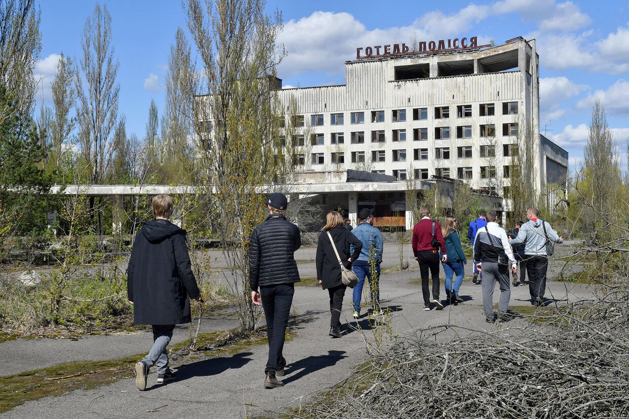 Туристы гуляют по городу-призраку Припять во время экскурсии в в Чернобыльскую зону отчуждения