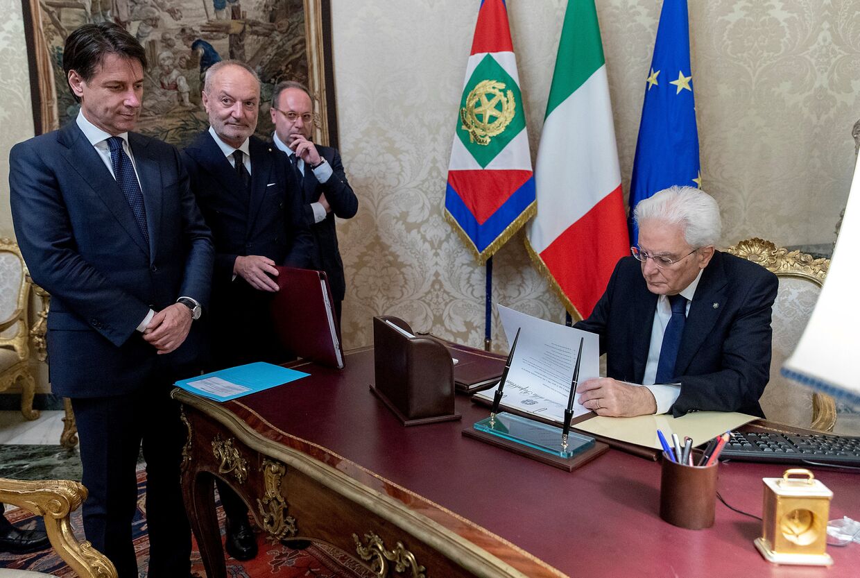 Назначенный премьер-министром Италии Джузеппе Конте смотрит, как президент Италии Серджо Маттарелла подписывает документы, Италия. 31 мая 2018