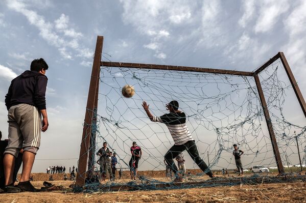 Палестинская молодежь играет в футбол у границы с Израилем