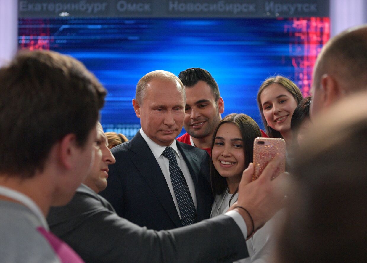 Президент РФ Владимир Путин фотографируется с волонтерами после ежегодной специальной программы Прямая линия с Владимиром Путиным в Гостином дворе. 7 июня 2018