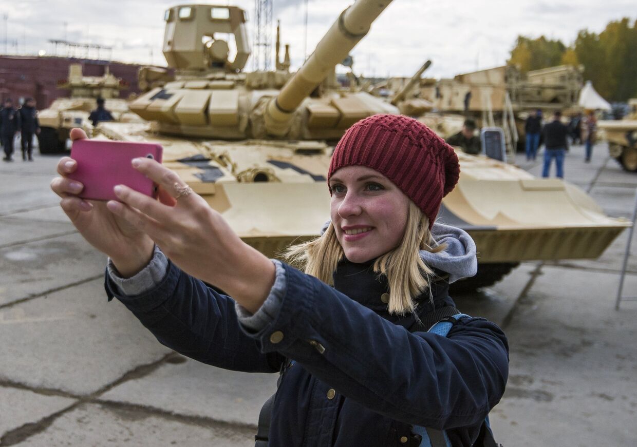 Посетитель фотографируется на фоне танка Т-90А на 10-й международной выставке Russia Arms Expo