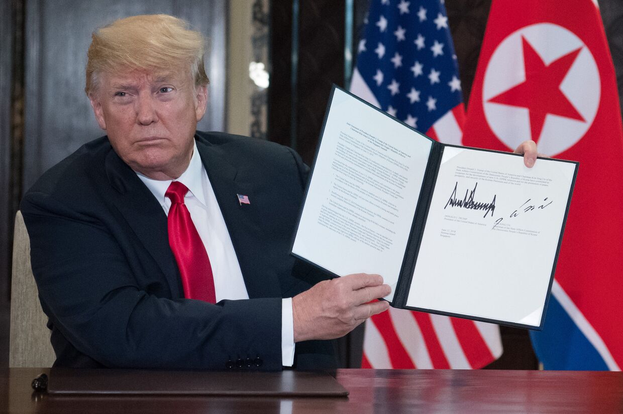 Президент США Дональд Трамп с подписанным совместно с лидером КНДР Ким Чен Ыном документом по итогам встречи в Сингапуре. 12 июня 2018