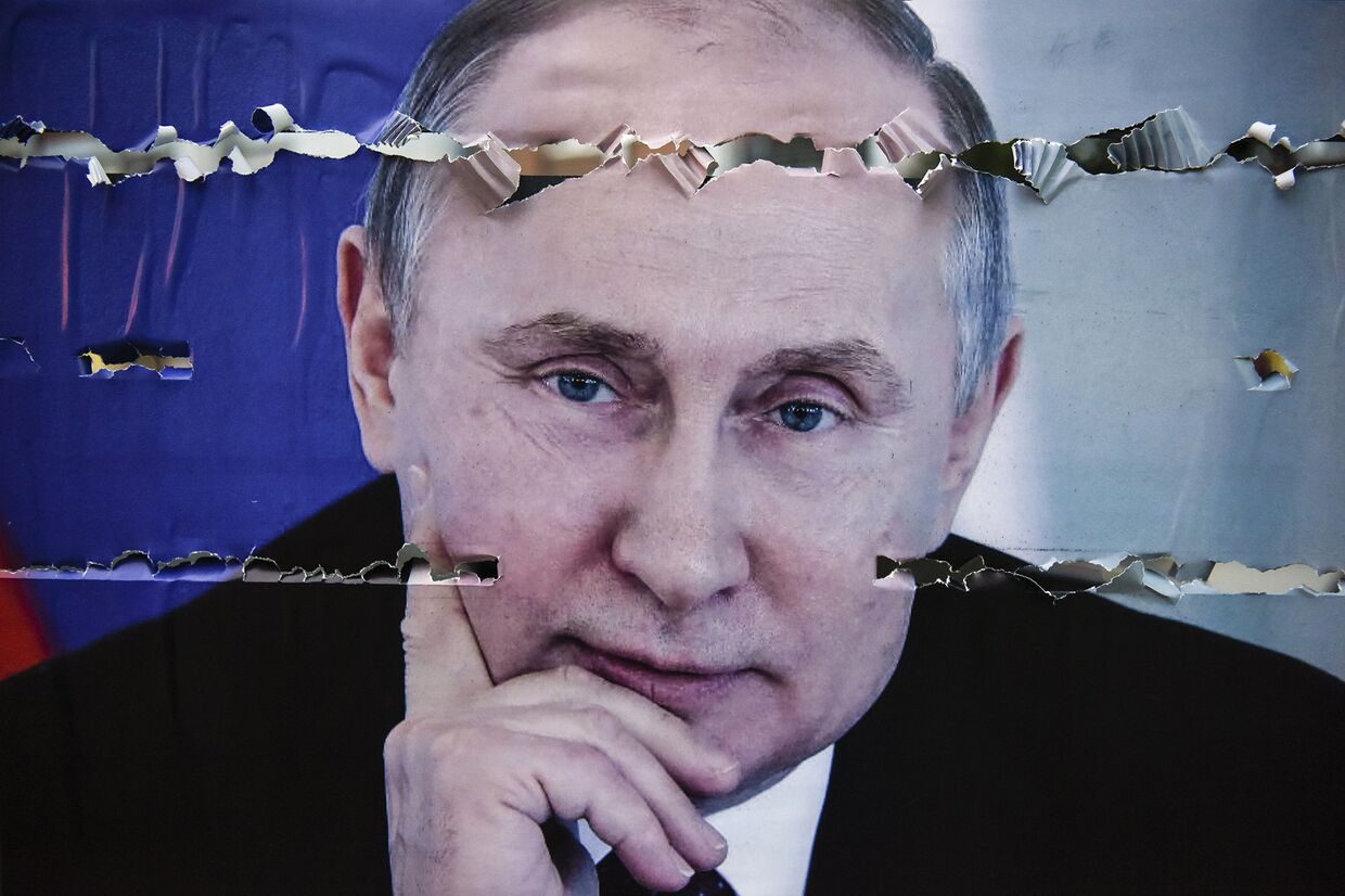 Разорванный плакат с изображением президента России Владимира Путина в Митровице, Сербия