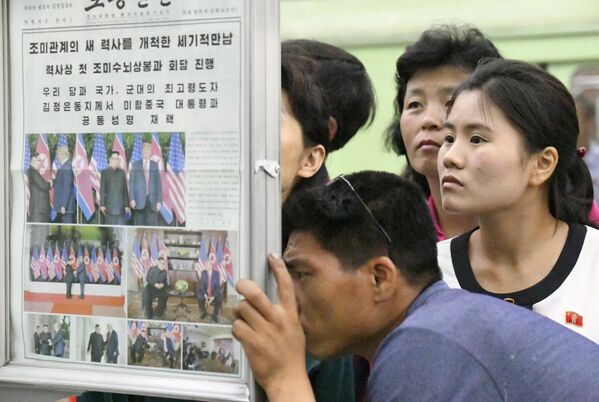 Местные жители читают в газетах о саммите США и КНДР в Пхеньяне