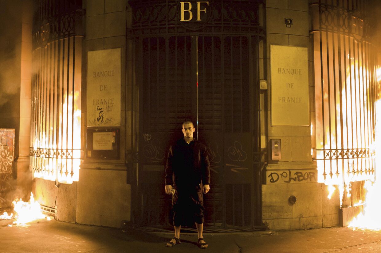 Художник-акционист Петр Павленский, стоящий перед горящим зданием Банка Франции. 16 октября 2017