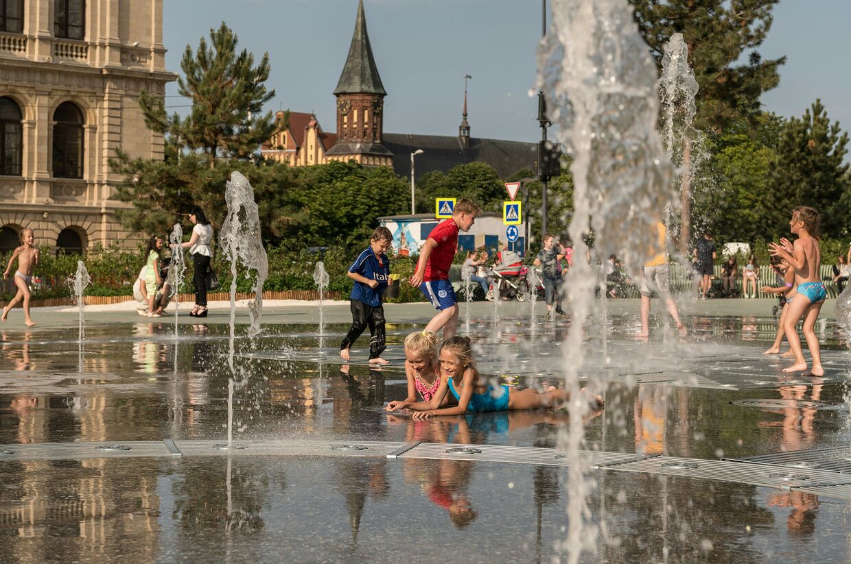 Дети играют в фонтане возле фан-зоны в Калининграде
