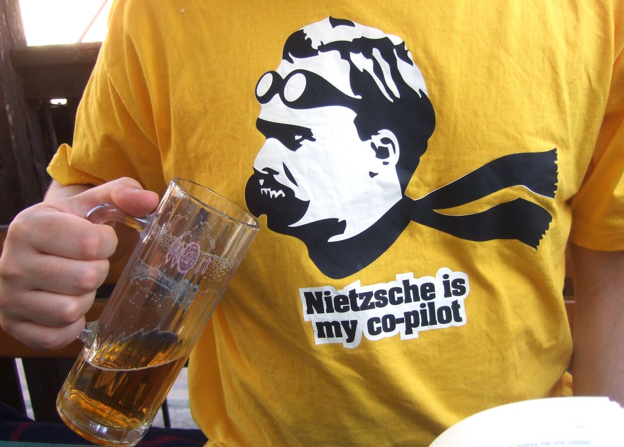 Мужчина в футболке с надписью Ницше - мой второй пилот