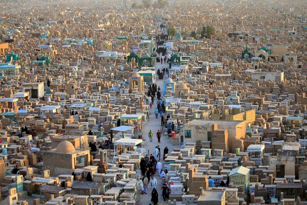 Люди посещают кладбище «Долина мира», отмечая конец месяца поста Рамадана