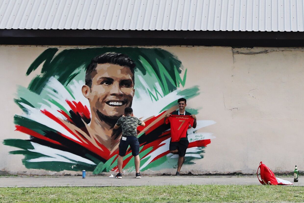Болельщики рисуют граффити с изображением игрока сборной Португалии Криштиану Роналду перед матчем ЧМ-2018 по футболу между сборными Ирана и Португалии в Саранске.