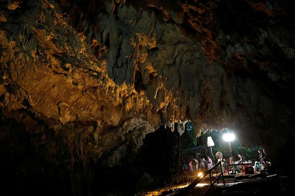 Журналисты работают у входа в пещеру Тхам Луанг