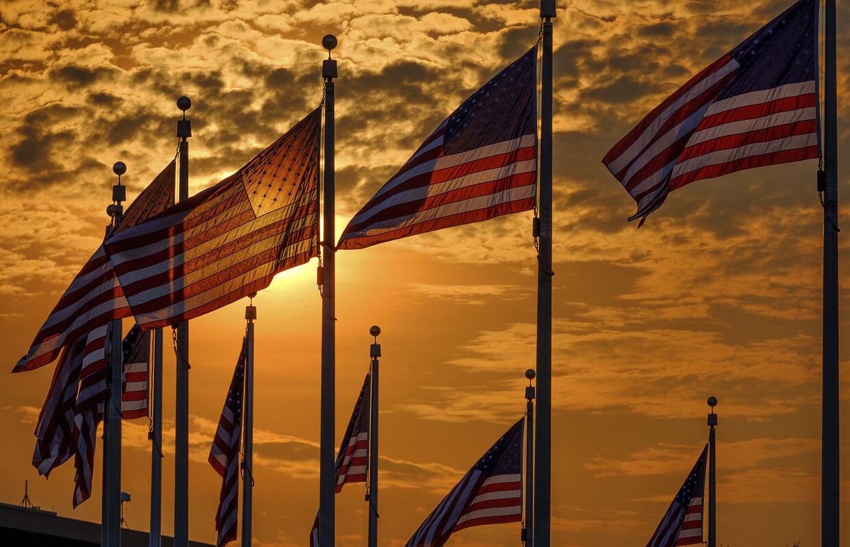 Флаги США вокруг монумент Вашингтона в День независимости США