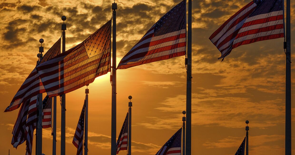 Флаги США вокруг монумент Вашингтона в День независимости США