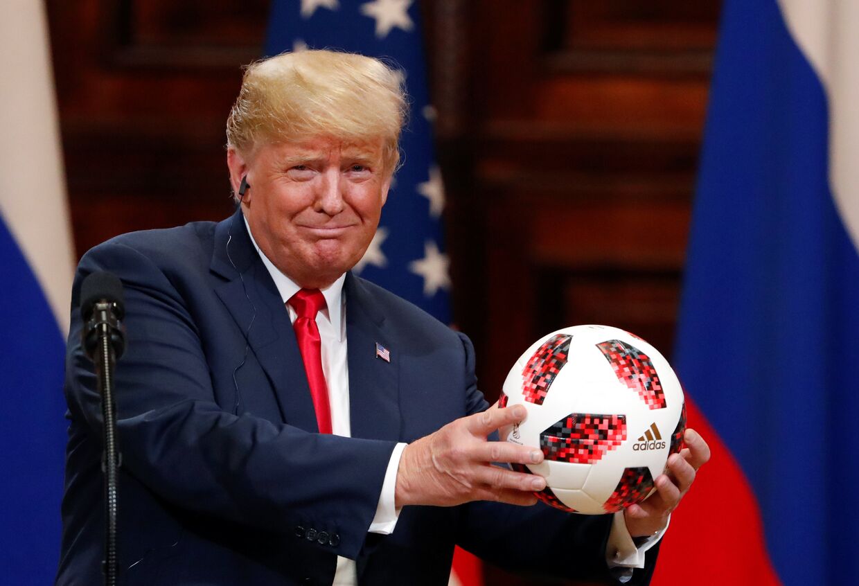 Президент США Дональд Трамп держит футбольный мяч, который ему дал президент России Владимир Путин
