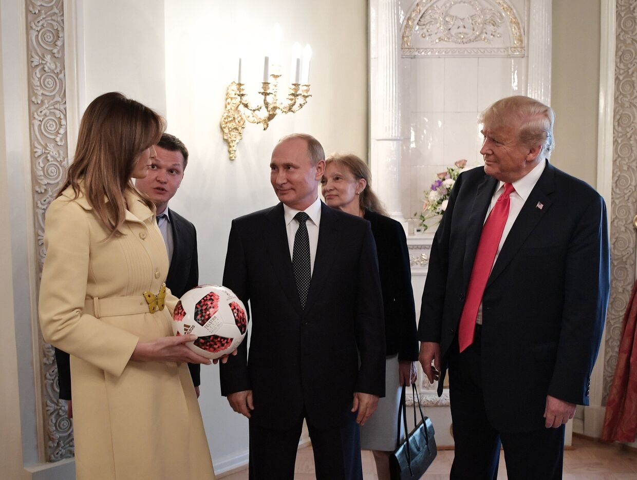 Президент РФ Владимир Путин и президент США Дональд Трамп с супругой Меланьей с мячом чемпионата мира 2018 по футболу во время встречи в Хельсинки