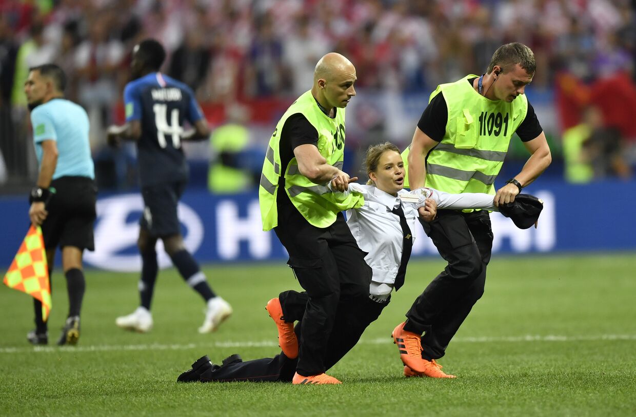 Охрана утаскивает участницу Pussy Riot, которая выбежала на поле во время матча Франция — Хорватия в финале ЧМ по футболу в Москве