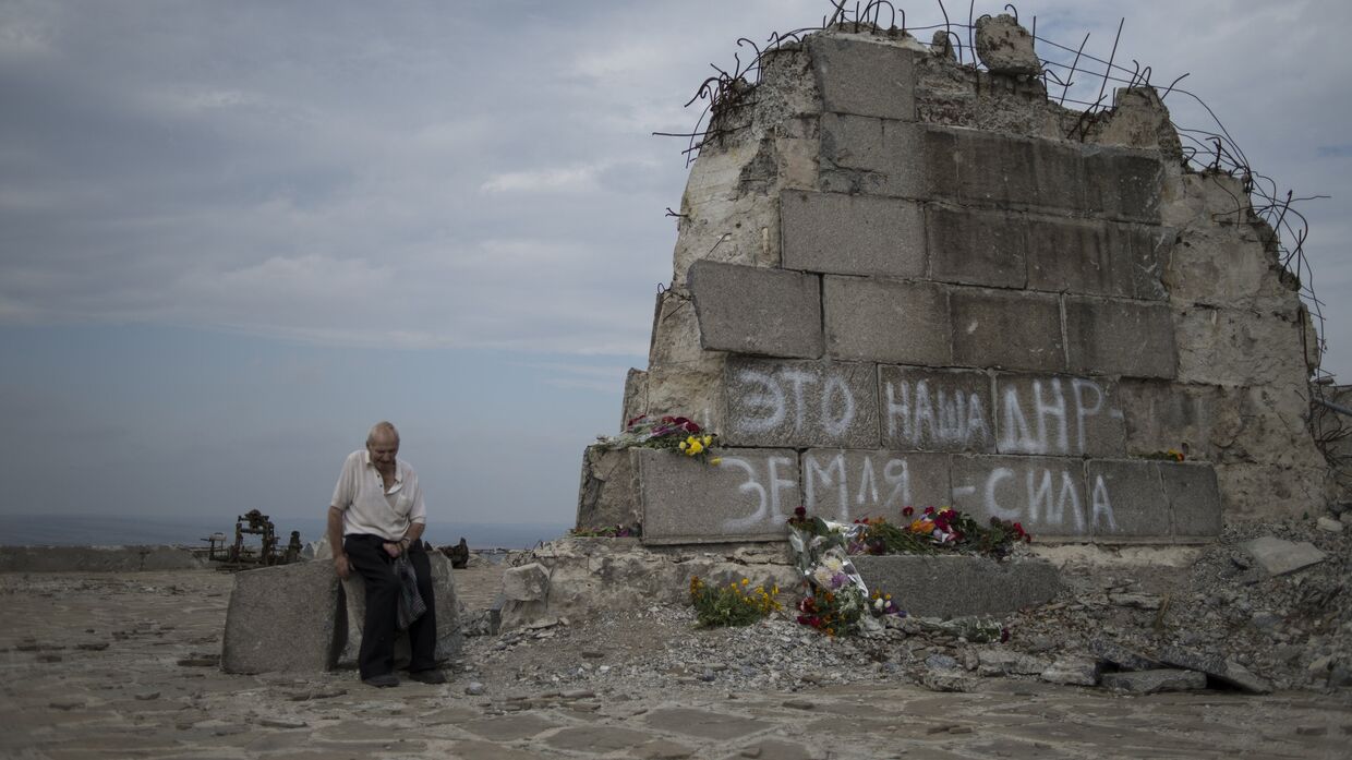 Мужчина у мемориала на кургане Саур-Могила в Донецкой области