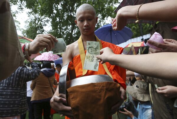 Буддийский монах собирает пожертвования для футбольной команды, спасенной из затопленной пещеры в Тайланде